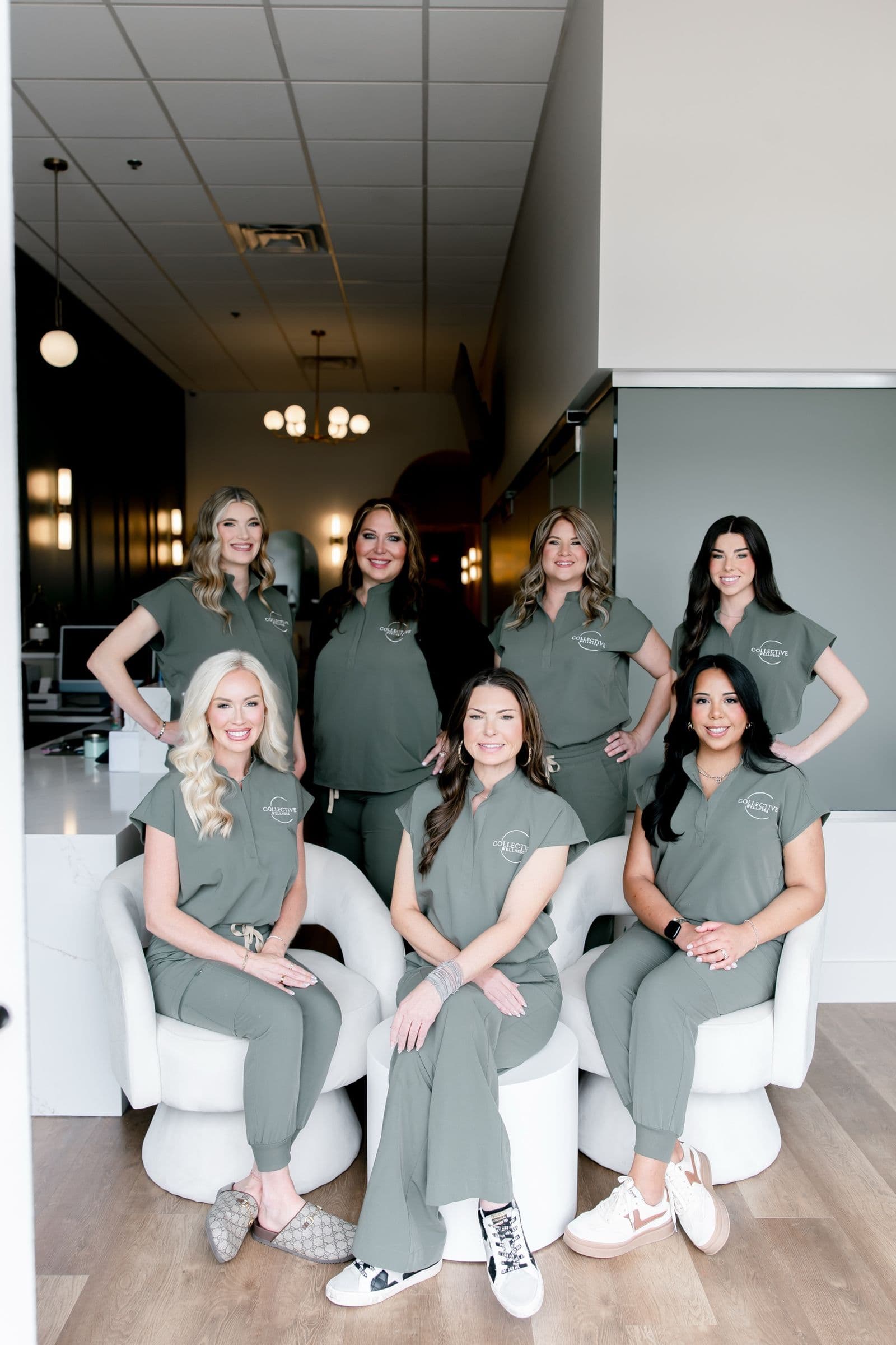 The full Collective Wellness medical spa team seated and standing together in the clinic lobby in Little Rock, AR